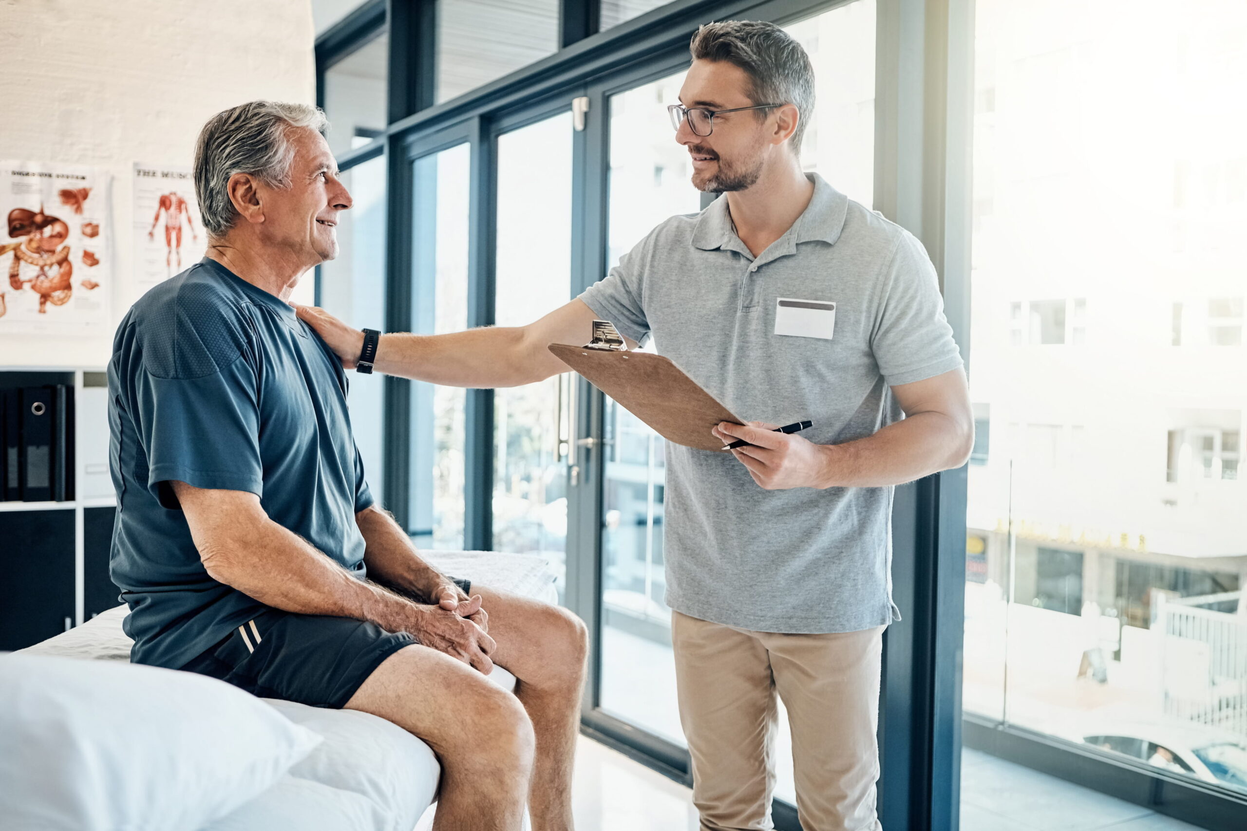 Physiotherapist consulting with a patient and holding a clipboard